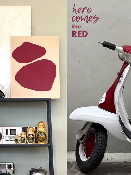 Here comes the red. A pop of color from a red scooter parked outside a cafe, coordinated with abstract art inside.