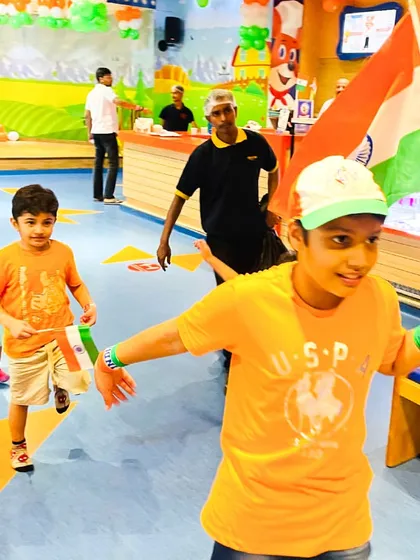 A boy leads a small parade with an Indian flag during our patriotic celebrations.