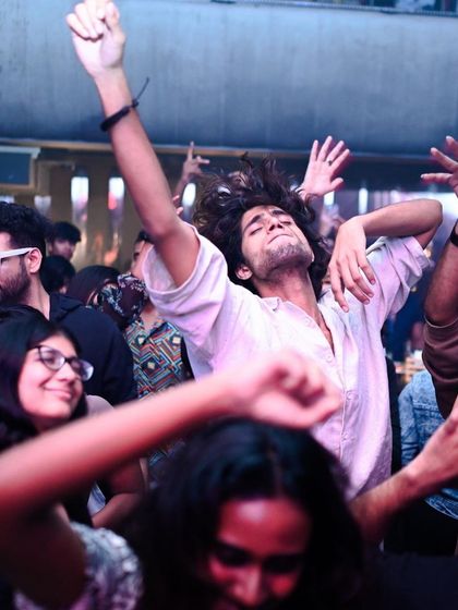 A partygoer lost in the music, hair flying, embodying the freedom of the dance floor.