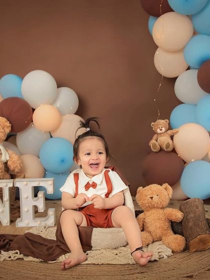 Bear hugs for this one-year-old. Our teddy bear picnic theme is a classic and adorable choice for a first birthday shoot, creating warm and cuddly portraits.