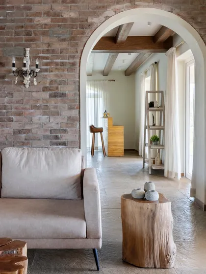 Another perspective of the living room, showing how the archway frames the view into the adjacent bar area, creating depth and visual interest.