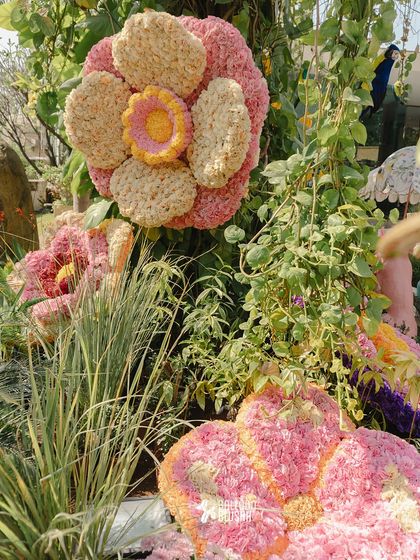 A close-up of a giant, multi-layered flower sculpture made from thousands of individual blossoms.