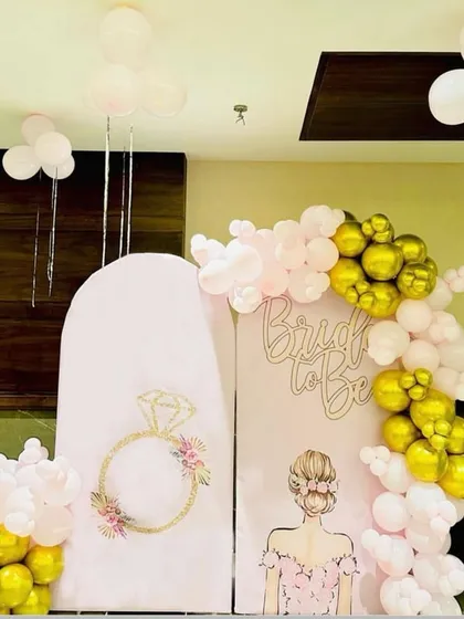 For a truly personal touch, I offer custom backdrops like this one for a bridal shower. It features two illustrated panels, one with a floral ring design and the other with a bride graphic, along with 'Bride to be' lettering. The pink and gold balloon garland completes this chic and modern party decoration.