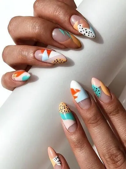 Showcasing my skill in detailed patterns, this abstract nail art combines geometric shapes, dots, and blocks of color on a long almond nail. This is a great example of a fully custom graphic design.