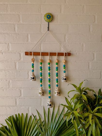 Our 'Beads and Bells' handmade wall hanging in the 'Blue Orchid' variant. The blue and green wooden beads paired with hand-painted ceramic bells create a cool and calming effect, perfect for any space.