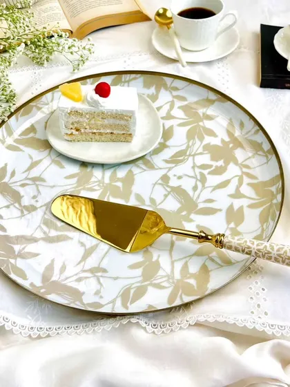 This gift set from our Handloom Harmony collection features a sleek round serving tray and a matching cake server. The neutral tones and sophisticated pattern make it an ideal gift for any occasion.