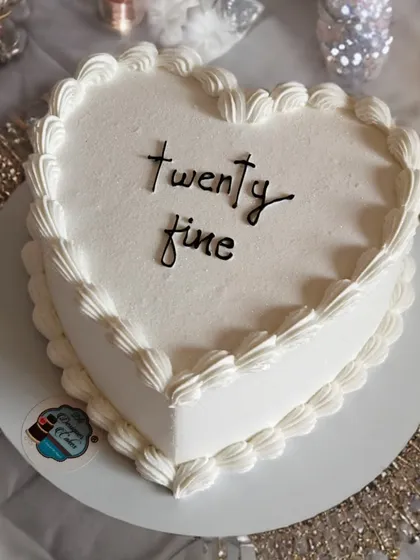 A minimalist heart-shaped cake with the simple message "twenty fine". This is a chic and modern design, perfect for a stylish 25th birthday.
