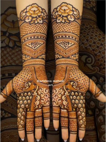 This design showcases peacocks on the palms with their feathers creating a swirling, intricate pattern. The arms feature geometric bands and a bold floral cuff for a modern yet traditional feel.