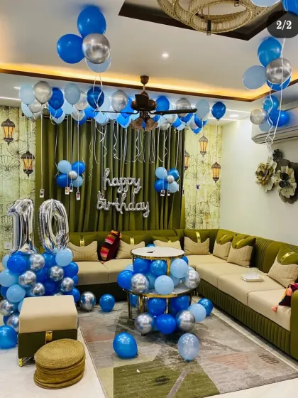 A full living room decoration for a 10th birthday with blue and silver balloons.