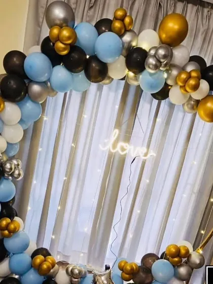 This stylish balloon ring combines light blue, black, white, and chrome gold balloons for a modern look. The simple "love" neon sign makes it a versatile backdrop for anniversaries, engagement parties, or Valentine's Day.