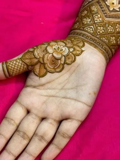 A beautiful close-up of a single shaded rose design on the thumb, part of a larger piece, showcasing our skill in creating realistic floral elements.