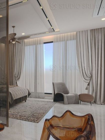 A view of the entire room, showing the light and airy feel created by the large windows and sheer curtains.