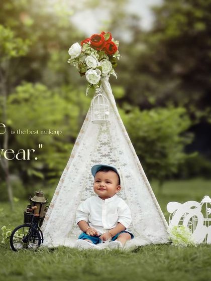 A smile is the best makeup. This happy baby boy enjoys his outdoor first birthday session in a charming lace teepee setup.