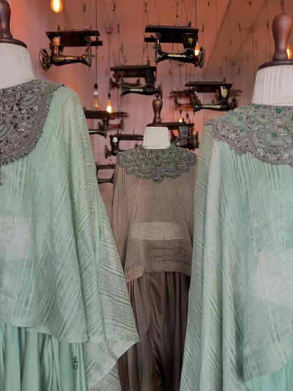 Another view of the Prisho outfits against the backdrop of our signature sewing machine wall art, where craft meets couture.
