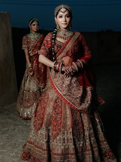 A full-length shot from a campaign, showcasing a bride in a magnificent red lehenga.