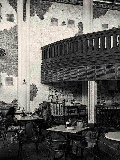 Patrons enjoying a meal in one of the restaurant's many seating zones. The design creates different environments, from casual tables to more formal setups.