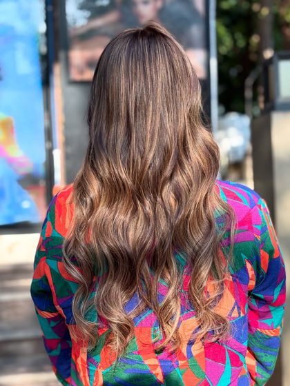 The back of this caramel honey hair color shows the beautiful blend of warm tones, perfect for a sunny glow.