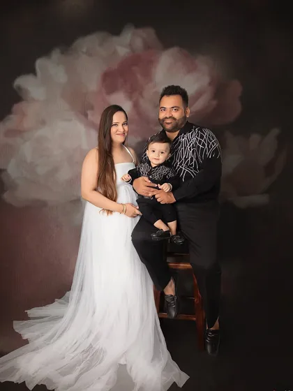 A beautiful family portrait celebrating their son's first birthday. The classic black and white outfits create a sophisticated and timeless look.