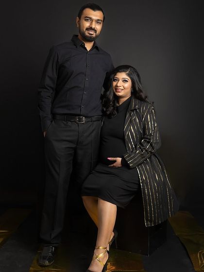 A confident and stylish full-length portrait of the couple. They are posed together against a dark background, creating a powerful and elegant image that feels both modern and timeless.