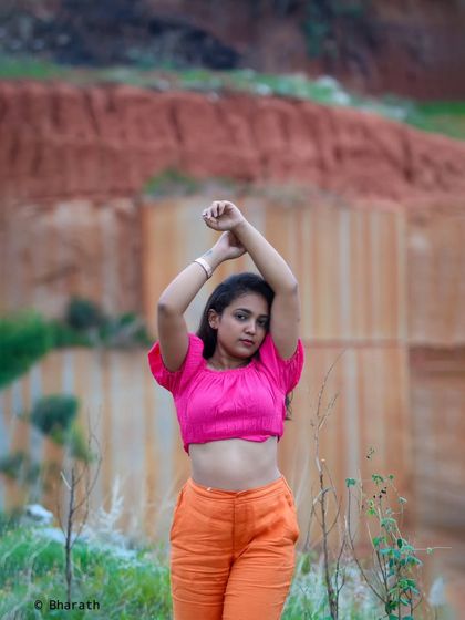 This powerful pose with arms raised creates a strong silhouette against the textured background of the quarry.