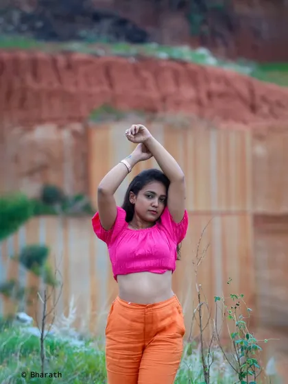A wider version of the "arms up" pose, showing more of the unique outdoor location.