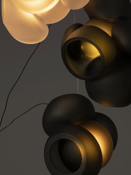 A close-up of the Bocci 100 series in a dark grey finish, showing the contrast between the matte exterior and the warm, glowing interior.