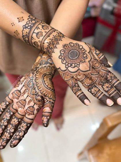 Another view of the engagement mehendi, showing the beautiful contrast between the detailed mandala on the back of the hand and the intricate jhumka (earring) motifs on the palm.