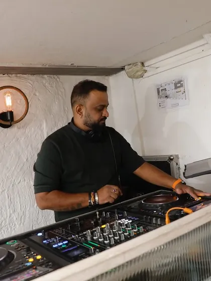 A moment of gratitude for the music. A clear shot of me at my professional DJ setup at Olive, laptop and mixer ready. This is my office, and I love what I do.