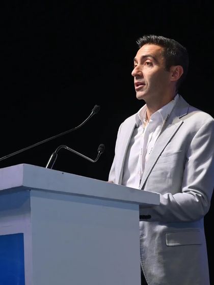 A speaker addresses a packed conference hall, delivering insights on the future of smart home technology.