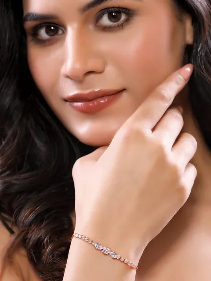 A model elegantly displays a contemporary rose-gold bracelet. The pose is designed to show how the piece sits on the wrist, providing valuable context for online shoppers.