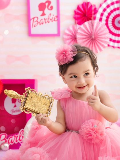 Come on Barbie, let's go party. This little girl gives a thumbs-up, fully embracing her fun and vibrant Barbie-themed birthday shoot.