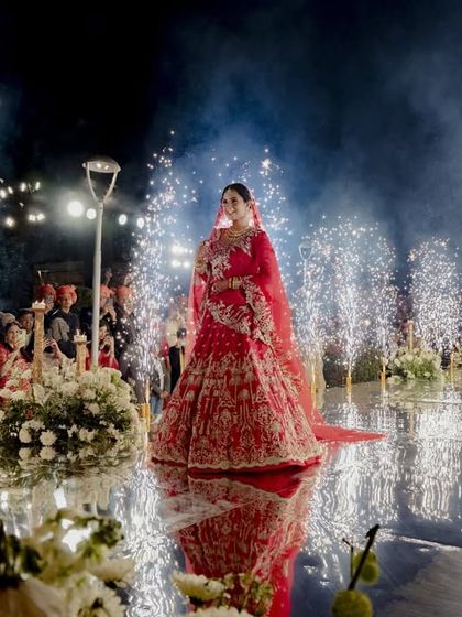 The bride's grand entrance on a mirrored aisle, lined with fountains of cold pyrotechnics. This dramatic effect created a path of light and reflection, making her walk towards the mandap a truly cinematic moment.