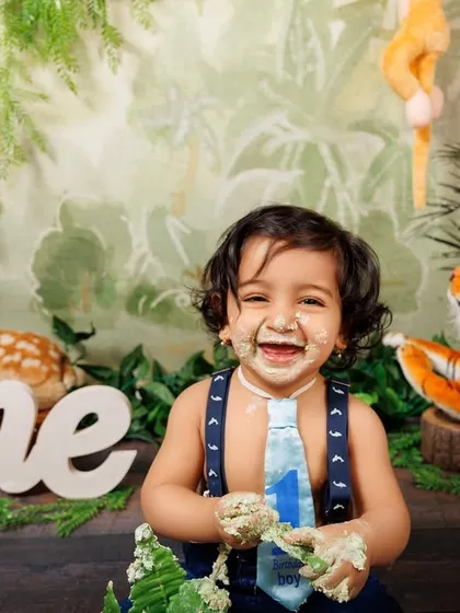 The best part of a cake smash! This little boy is covered in green frosting and loving it.