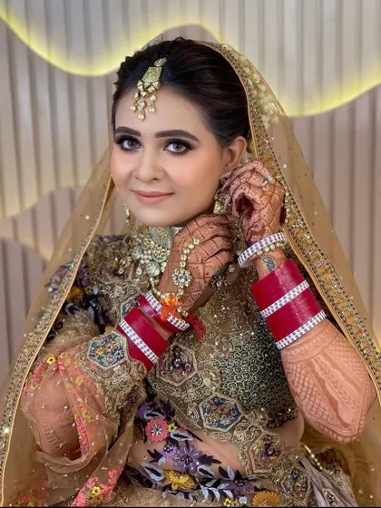 A close-up of the bride adjusting her earring, showing the detail of her jewellery and her happy expression.