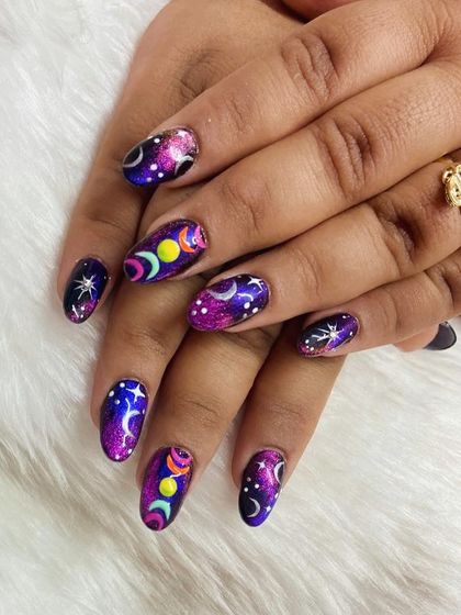 A close-up of the cosmic nails, highlighting the detailed moon phase art and the sparkling, starry background.