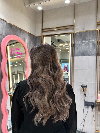 An ash blonde balayage that adds depth and dimension. This look is perfect for those who want a natural yet striking style with a touch of cool elegance, shown here with soft, flowing waves.