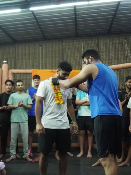 A teammate garlands a returning champion, a sign of respect and shared success within our gym.