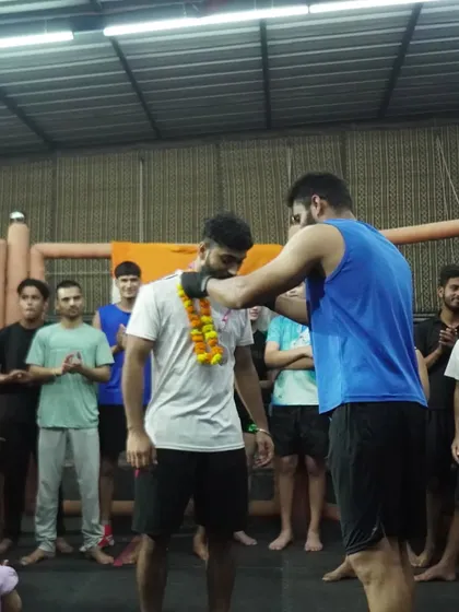 A teammate garlands a returning champion, a sign of respect and shared success within our gym.