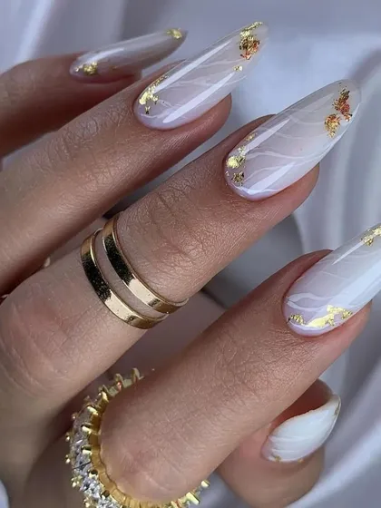 Experience elegance with our marble nail art. This design features long, almond-shaped nails with a soft white marble effect, beautifully accented with delicate flecks of gold foil for a touch of luxury.