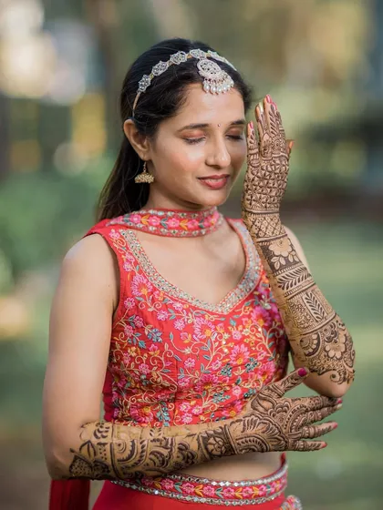 A graceful portrait of the bride admiring her detailed henna art.