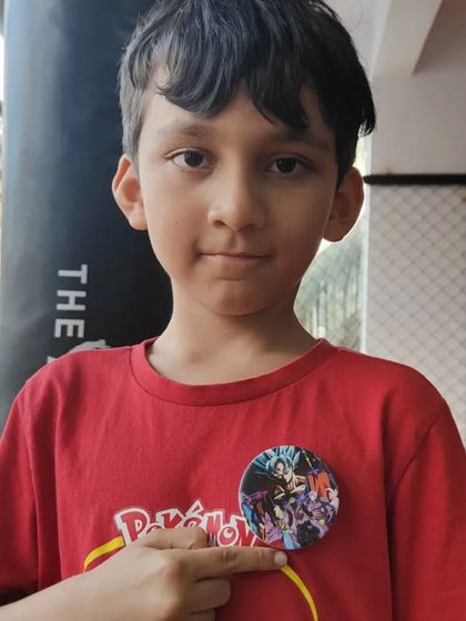 This young student proudly displays his badge of achievement. Our goal is to make every child feel like a champion after their training session.