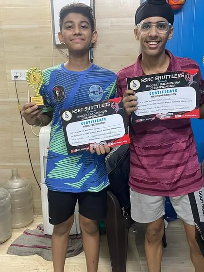 Success is a team effort. Two of our young champions proudly display their trophies and certificates after a successful tournament, showcasing the results of their consistent training.