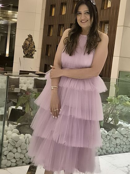 A happy client looking like a real-life Barbie in this custom lavender tiered dress. The soft tulle fabric and halter neck design make it a fun and fashionable choice for birthdays or parties.