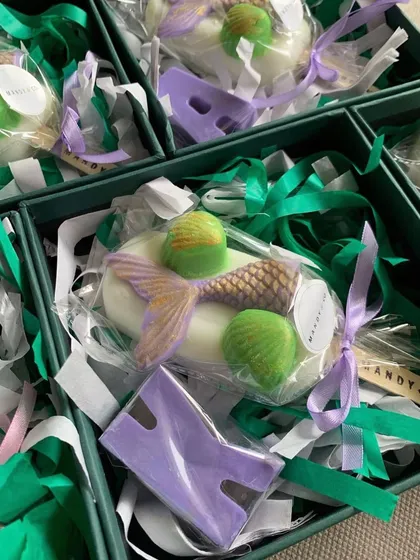A mermaid-themed gift box with a mermaid popsicle soap and a personalized initial soap in purple.