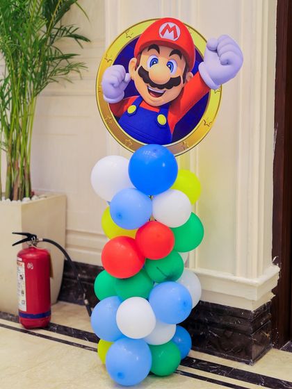 A Super Mario character cutout on top of a colorful balloon pillar. These are great for placing around the venue to reinforce the theme and add pops of color.