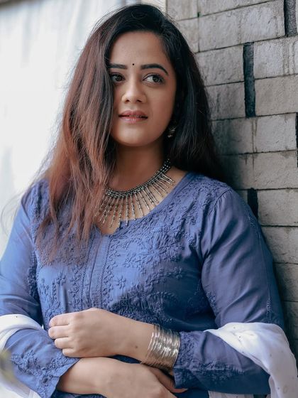 A close-up shot focusing on the detailed embroidery of the Pakeeza Chikankari kurta and the statement silver necklace worn by Spruha Varad.