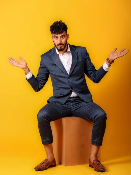 An expressive and slightly playful pose that breaks the mold of traditional male portraiture. It shows personality and a willingness to be open in front of the camera.