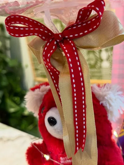 The beautiful red and gold ribbons that adorn the top of the balloon, adding a festive and high-quality finish.