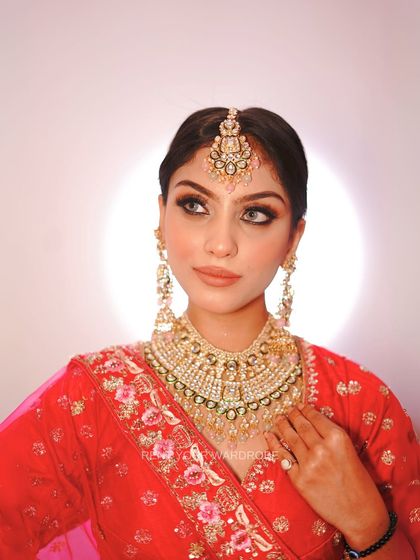 The right jewellery completes a bridal look. This shot highlights the beautiful kundan necklace and maang tikka paired with our pink lehenga.