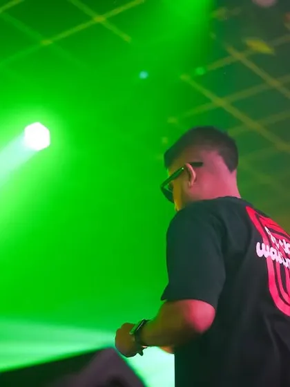 A shot from behind at Club EDL, with the green stage lighting creating a dramatic silhouette.